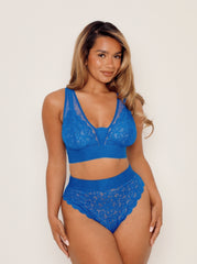 Woman wearing a blue lace lingerie set on a white background