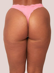Person wearing pink lace underwear on a plain background